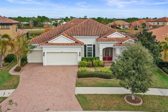 mediterranean / spanish-style house with a garage and a front yard