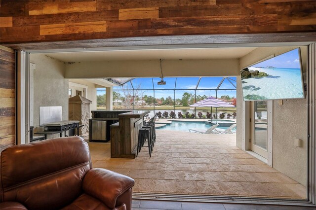 view of patio with glass enclosure and exterior bar