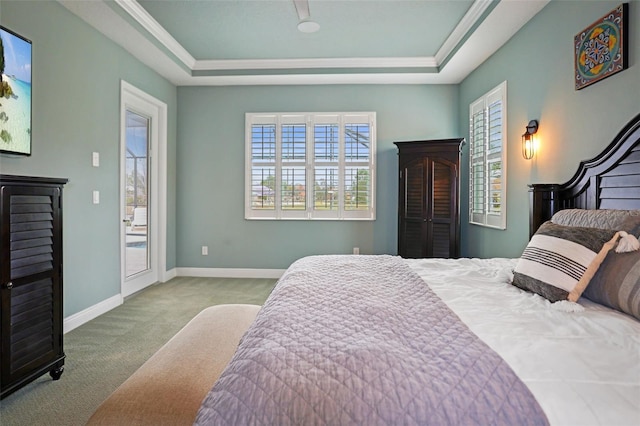 bedroom featuring light carpet, ornamental molding, a raised ceiling, and access to outside