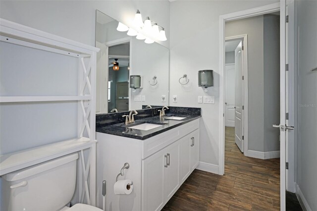 bathroom featuring wood-type flooring, toilet, and vanity