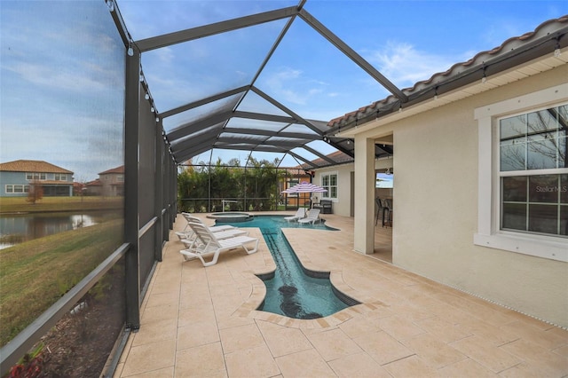 view of pool with a water view, a patio area, glass enclosure, and an in ground hot tub