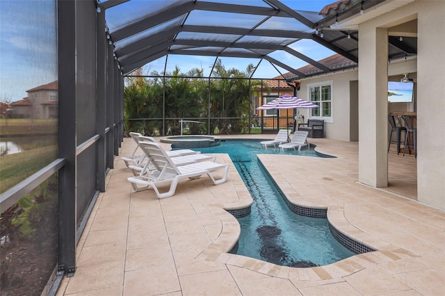 view of swimming pool featuring glass enclosure, an outdoor bar, an in ground hot tub, and a patio