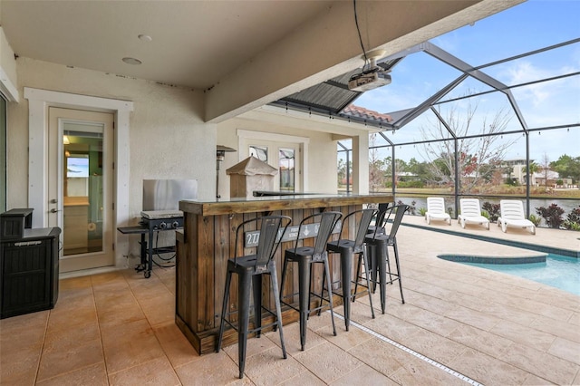 exterior space with a water view, exterior bar, and a lanai