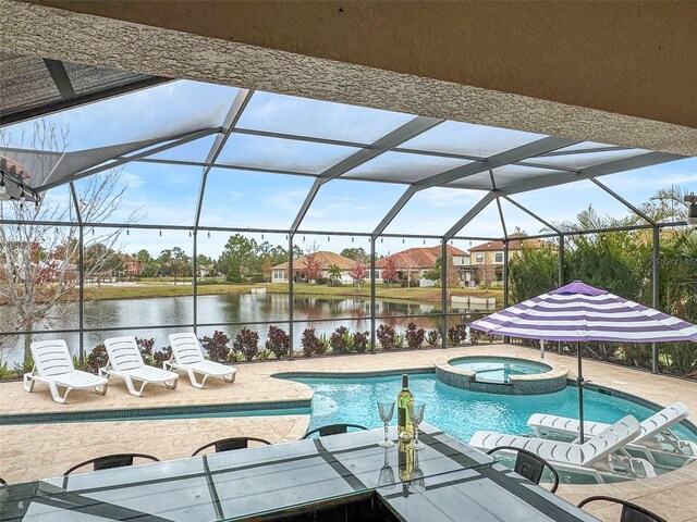 view of swimming pool featuring an in ground hot tub, a lanai, a water view, and a patio area