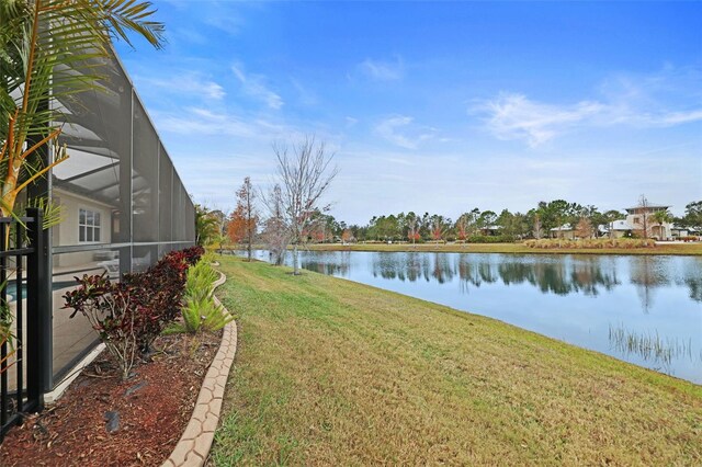 view of yard featuring glass enclosure and a water view