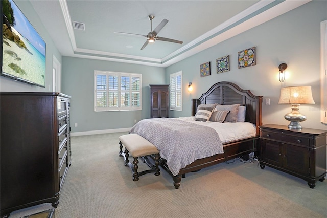 bedroom featuring a raised ceiling, ceiling fan, and light carpet