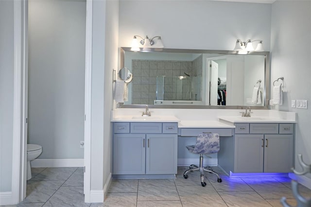 bathroom with toilet, vanity, and a tile shower