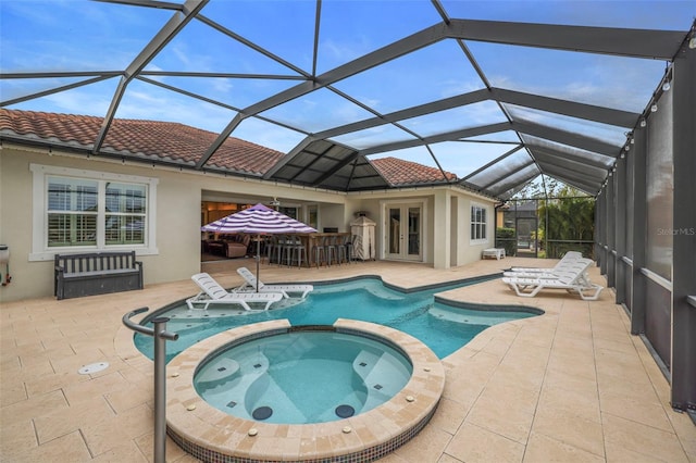 view of pool featuring french doors, a patio, glass enclosure, and an in ground hot tub