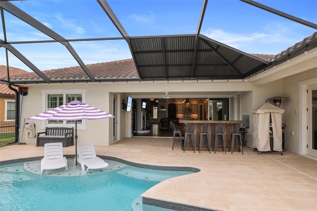 rear view of property with a lanai, a patio, and an outdoor bar