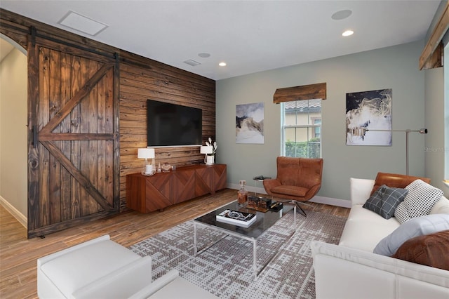 living room featuring a barn door and light wood-type flooring