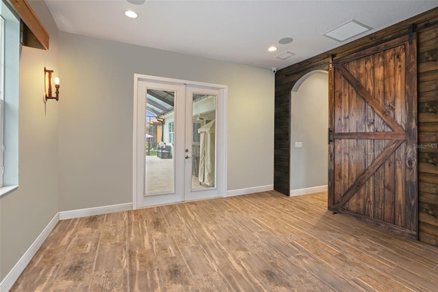 spare room with french doors and light hardwood / wood-style floors