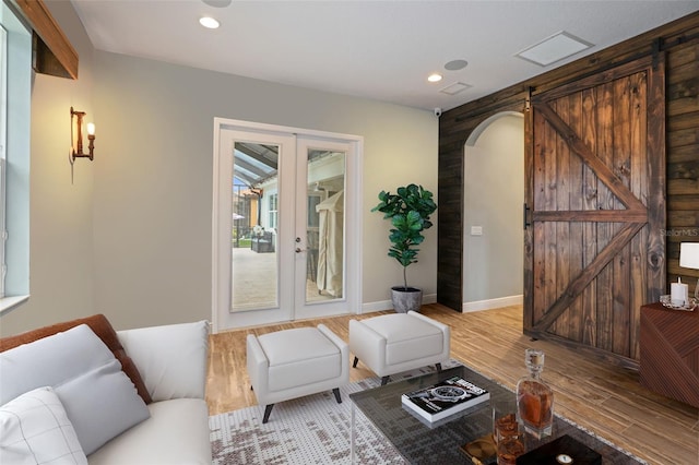 living room featuring light hardwood / wood-style flooring, french doors, and a barn door