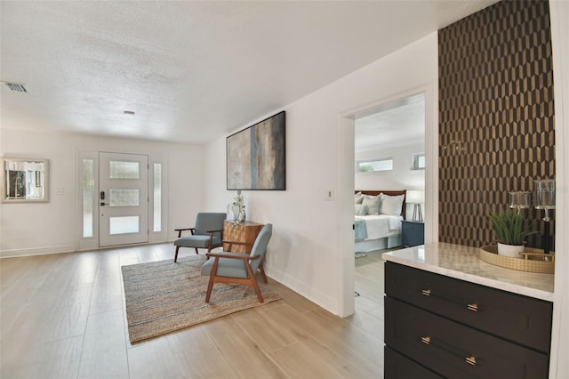 living area with light wood-type flooring and a textured ceiling