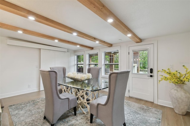 dining space featuring light hardwood / wood-style floors and beam ceiling