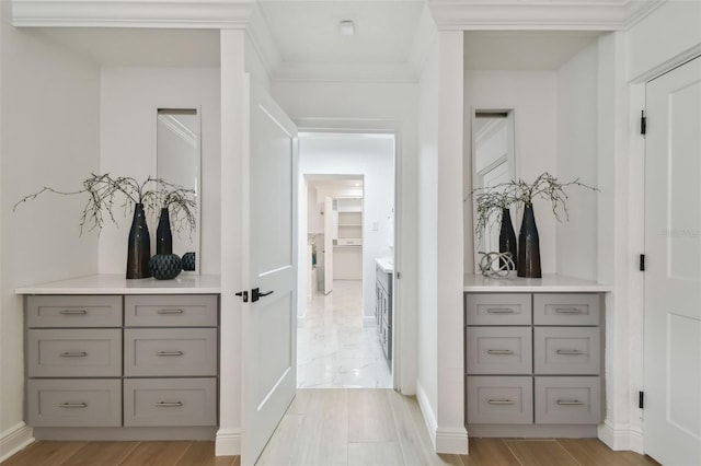 hall with light wood-type flooring and ornamental molding