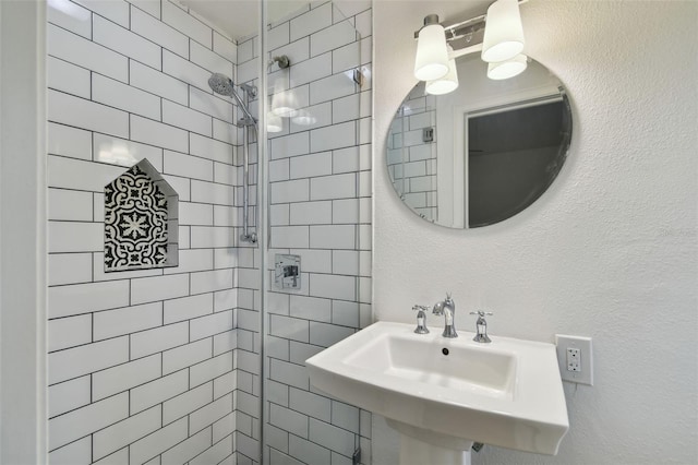 bathroom with a tile shower and sink