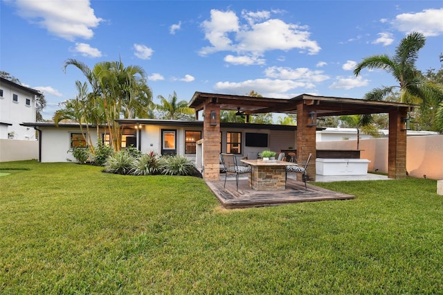 rear view of house with a patio area, a jacuzzi, a lawn, and an outdoor fire pit