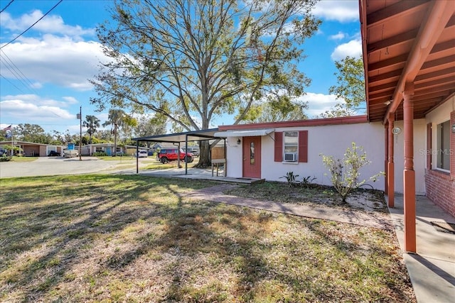 view of front of property with cooling unit, a front lawn, and a carport