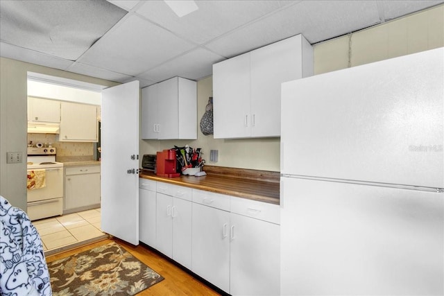 kitchen with white appliances, a paneled ceiling, white cabinetry, tasteful backsplash, and light hardwood / wood-style flooring