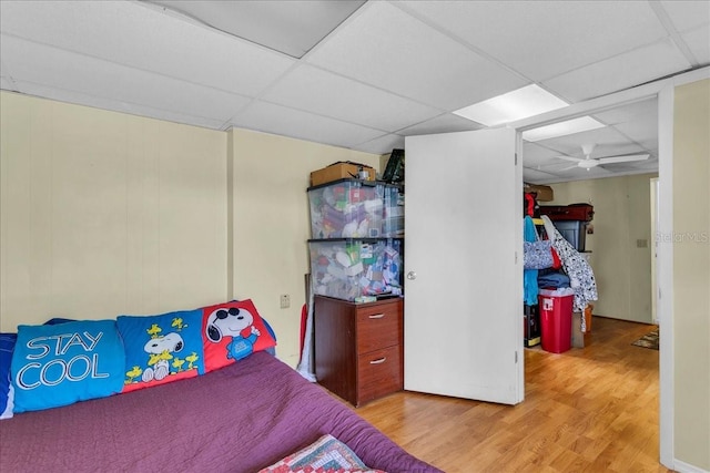 bedroom with a paneled ceiling and light hardwood / wood-style flooring