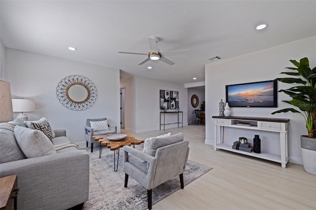 living room featuring light wood-type flooring and ceiling fan