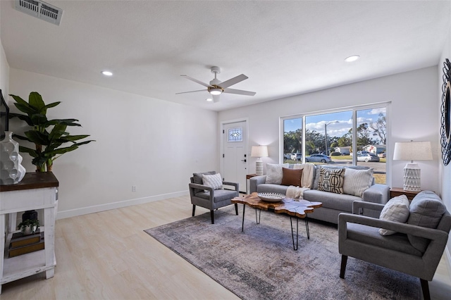 living room featuring light wood-type flooring and ceiling fan