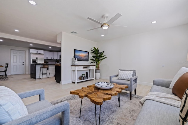 living room with light hardwood / wood-style floors and ceiling fan