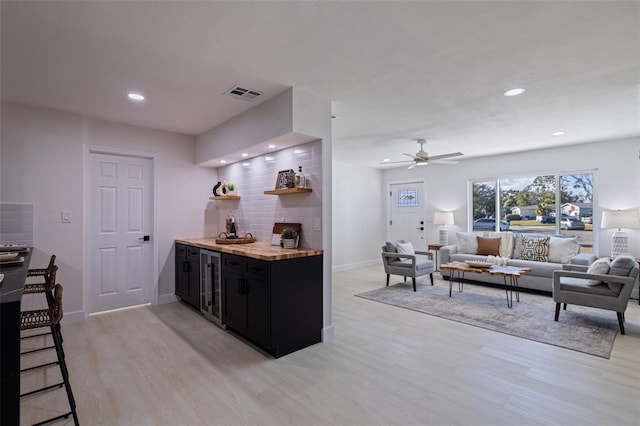 kitchen with wooden counters, ceiling fan, and light hardwood / wood-style floors