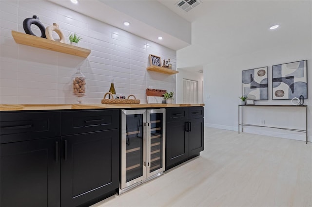 bar featuring beverage cooler and butcher block counters