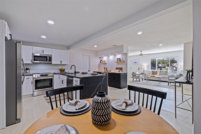 dining room featuring ceiling fan, light hardwood / wood-style floors, and sink