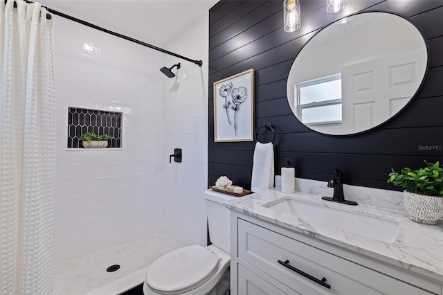 bathroom with toilet, vanity, wood walls, and a shower with curtain