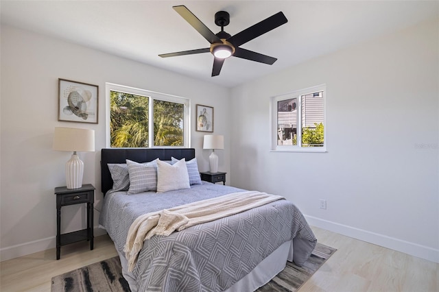 bedroom with multiple windows, ceiling fan, and light wood-type flooring