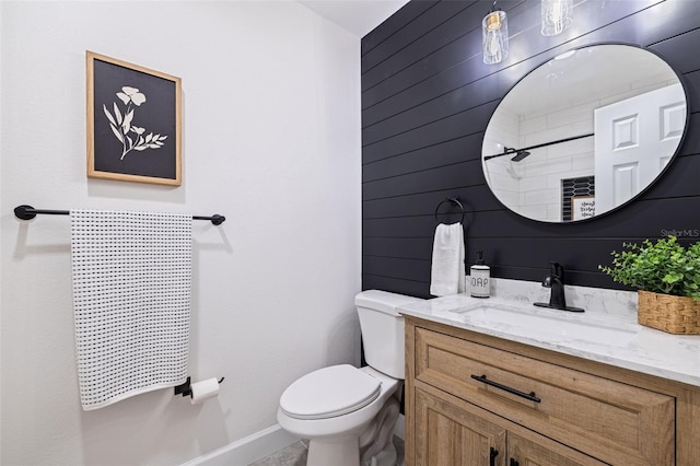 bathroom featuring wooden walls, vanity, and toilet