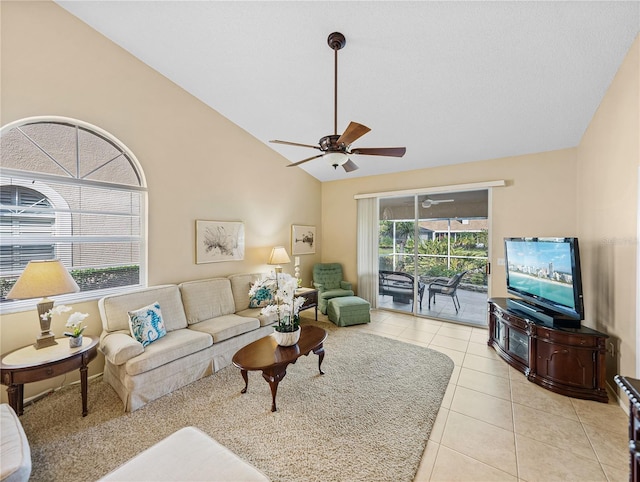 tiled living room featuring vaulted ceiling, ceiling fan, and a healthy amount of sunlight