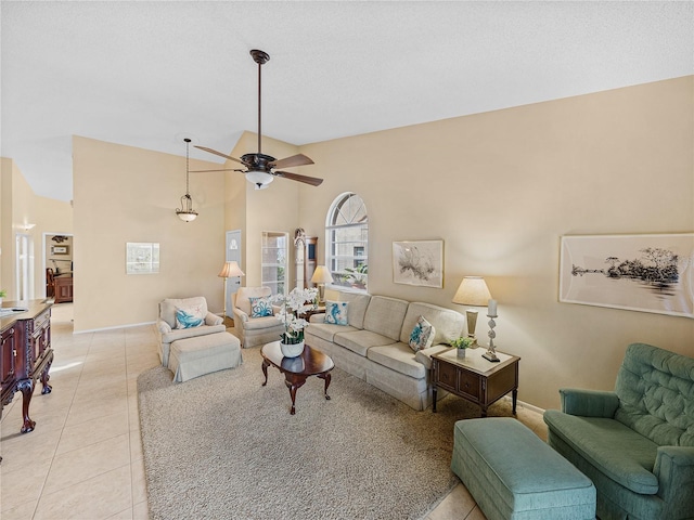 living room with ceiling fan, light tile patterned floors, and lofted ceiling