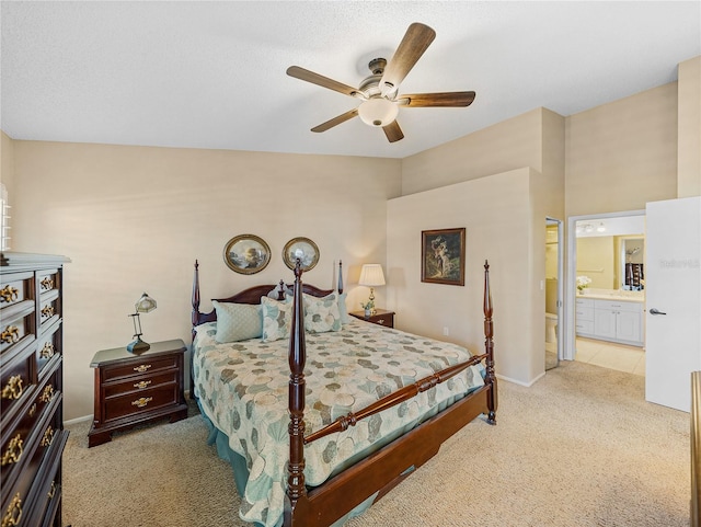 bedroom featuring light carpet, connected bathroom, and ceiling fan