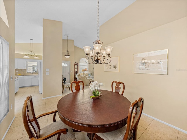 dining room featuring a notable chandelier, lofted ceiling, and light tile patterned flooring