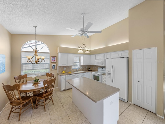 kitchen with sink, white cabinets, white appliances, and a kitchen island