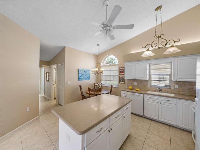 kitchen featuring sink, hanging light fixtures, white dishwasher, lofted ceiling, and white cabinets