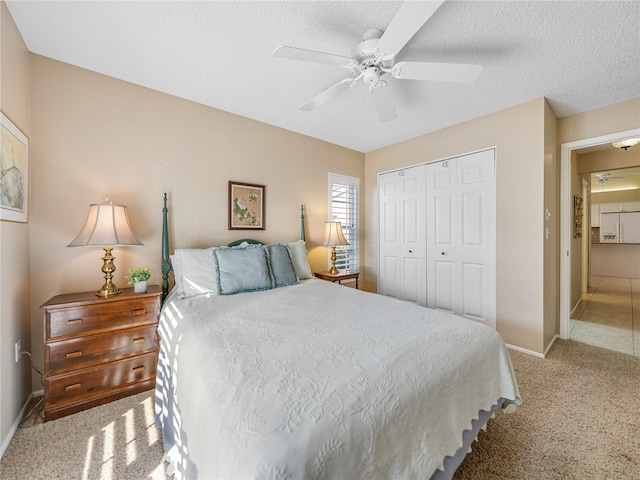 carpeted bedroom with a textured ceiling, a closet, and ceiling fan