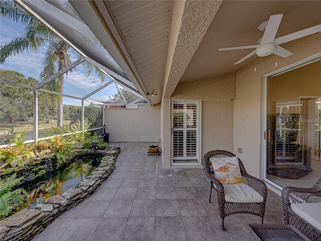 view of patio featuring glass enclosure and ceiling fan