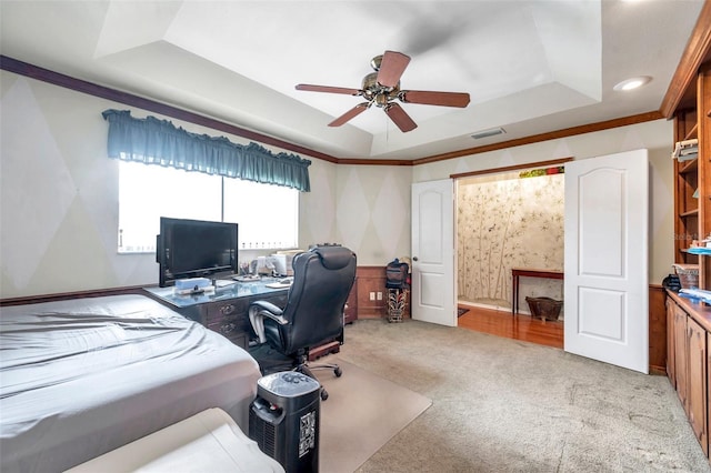 office space featuring light colored carpet, a raised ceiling, ceiling fan, and ornamental molding