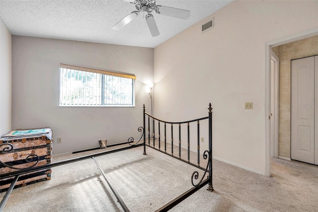 carpeted bedroom featuring a textured ceiling, ceiling fan, and lofted ceiling