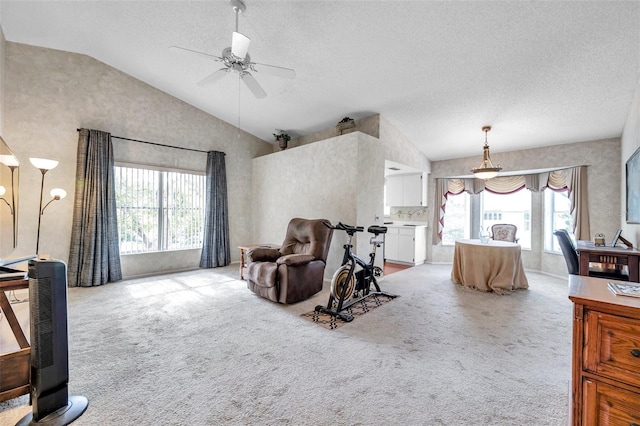 living room featuring light carpet, a textured ceiling, vaulted ceiling, and ceiling fan