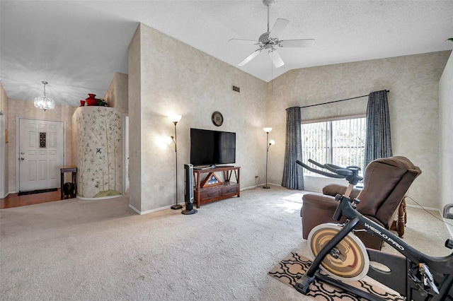 living room with ceiling fan with notable chandelier, a textured ceiling, carpet floors, and vaulted ceiling