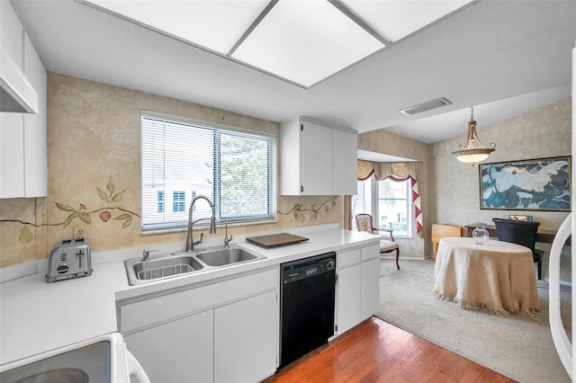 kitchen featuring sink, black dishwasher, decorative light fixtures, white cabinetry, and wood-type flooring