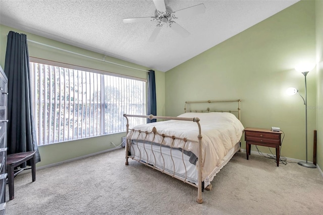 bedroom with a textured ceiling, ceiling fan, light carpet, and lofted ceiling