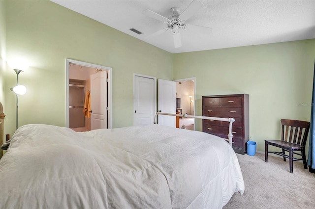 bedroom with a textured ceiling, ceiling fan, and light carpet