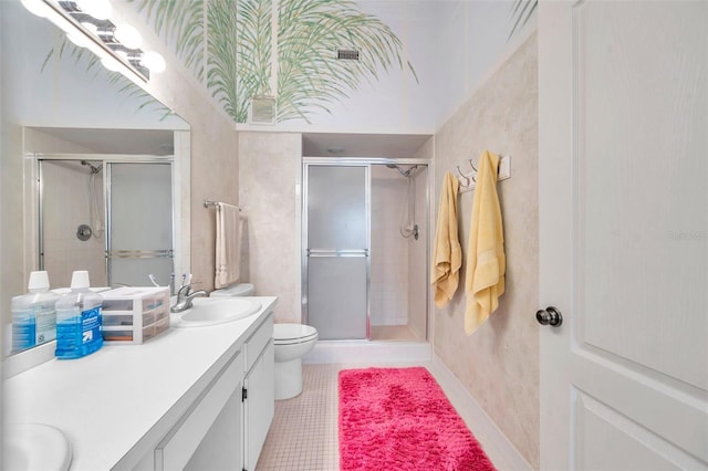 bathroom with tile patterned flooring, vanity, toilet, and a shower with door