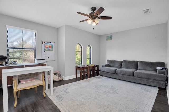 living room featuring ceiling fan and dark hardwood / wood-style flooring